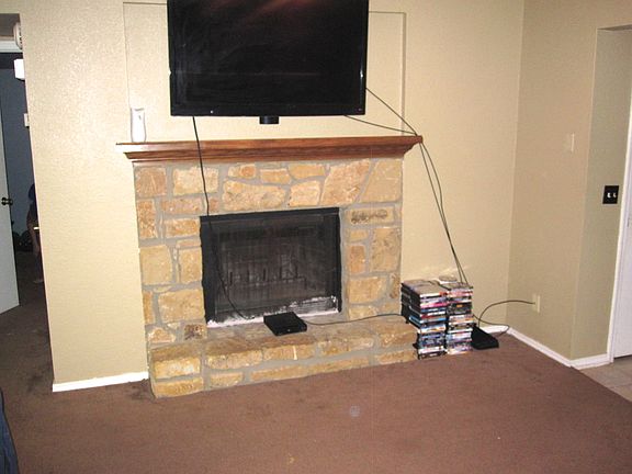 The living room is accomanied with a beautiful stone firepl