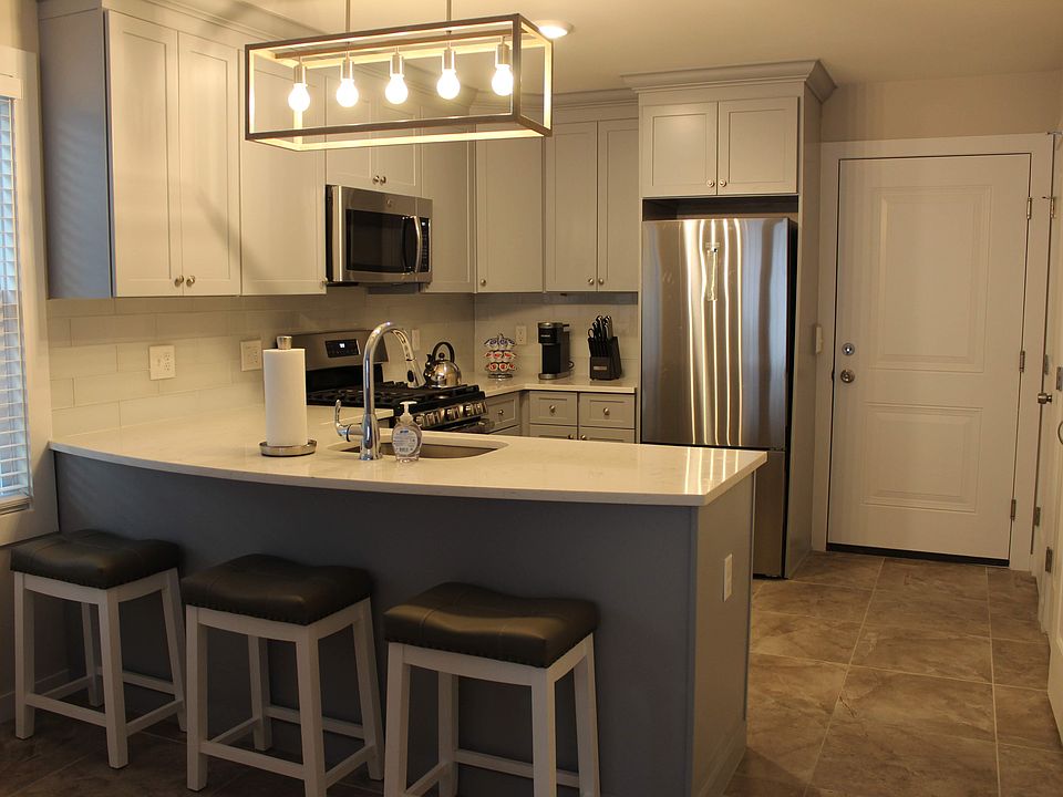 Bright, fully equipped kitchen with stainless steel appliances and island seating.