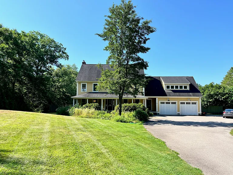 Front of house with covered porch and 2 car attached garage.