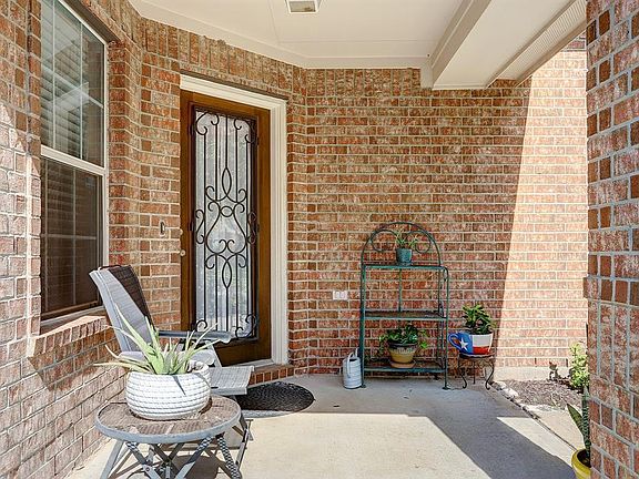 Guests are welcomed by this charming covered front porch and beautiful wood and leaded glass door with decorative iron inlay. Let's take a look inside.