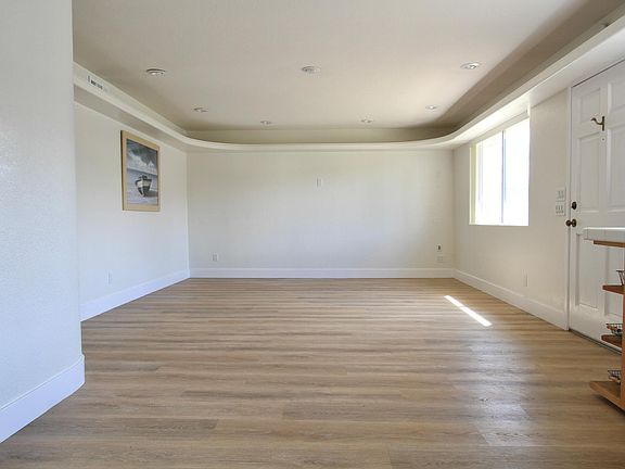 Standing in the kitchen and facing the family room area.