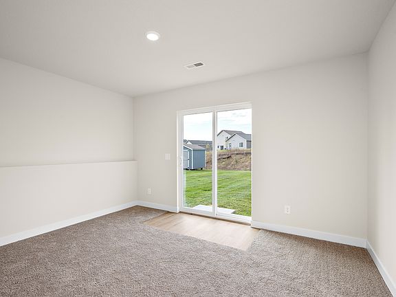The kitchen has stainless steel appliances and plank flooring.