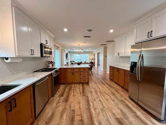Open concept living, dining, and kitchen with many windows for lots of natural light