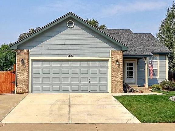 Extra wide driveway with parking pad behind fence