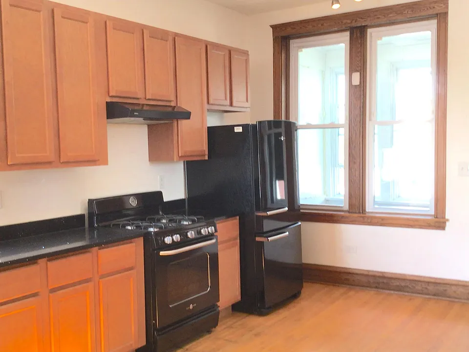 Kitchen features overhead LED lighting, vented cooking area, and large cabinets.