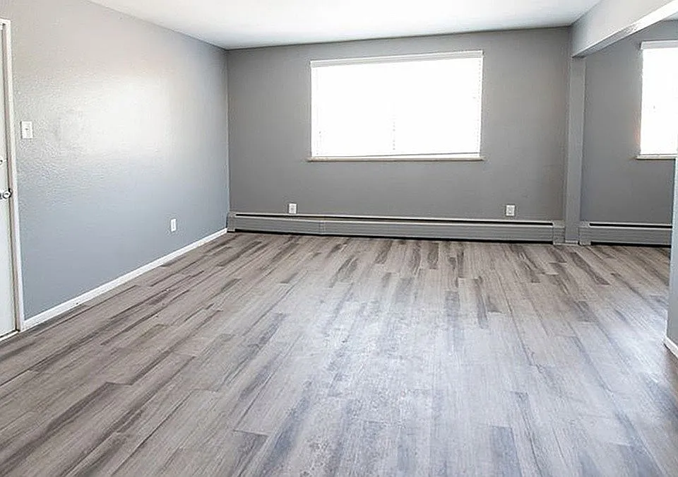 Bright and spacious living area with sleek gray flooring and modern neutral walls, perfect for stylish urban living.