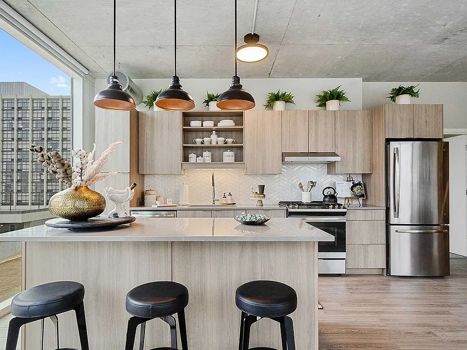 A spacious kitchen island, stainless steel appliances, and contemporary cabinetry create a polished, functional setting for everything from morning coffee to casual entertaining.