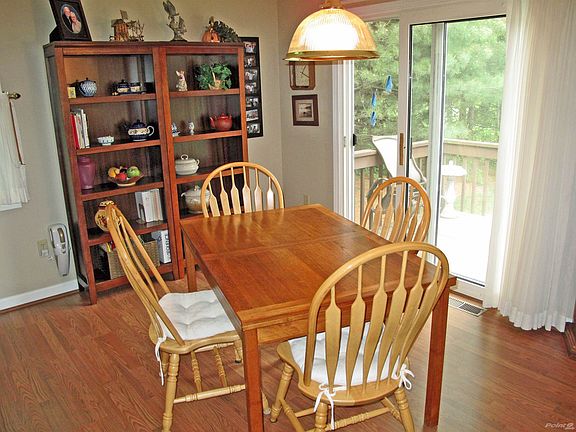 Dining Area features pergo-type flooring and a slider to the deck and lush, grassy yard beyond.