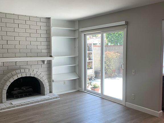 Family room off kitchen with brick fireplace with mantle, built-in shelves