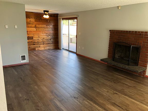 Living room and dining room. Fireplace to right, as seen fro
