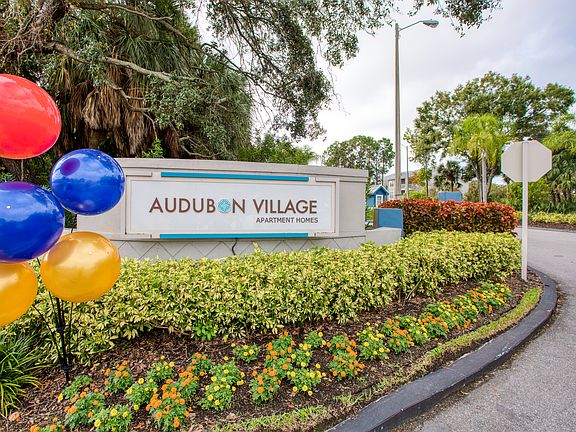 Audubon Village - Image of the front entrance monument sitting on a bed of flowers.