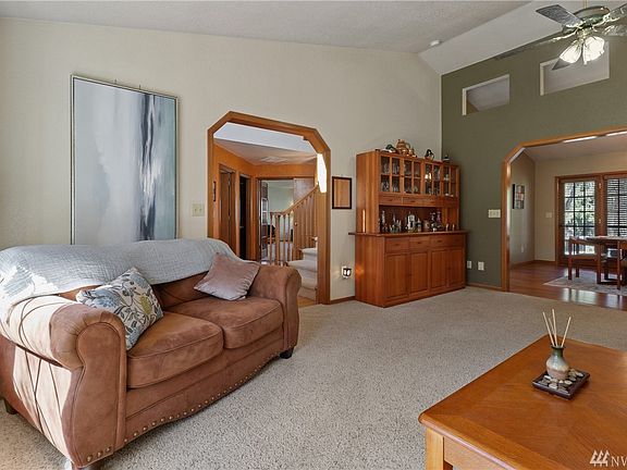Living room leads to formal dining offering vaulted ceiling.