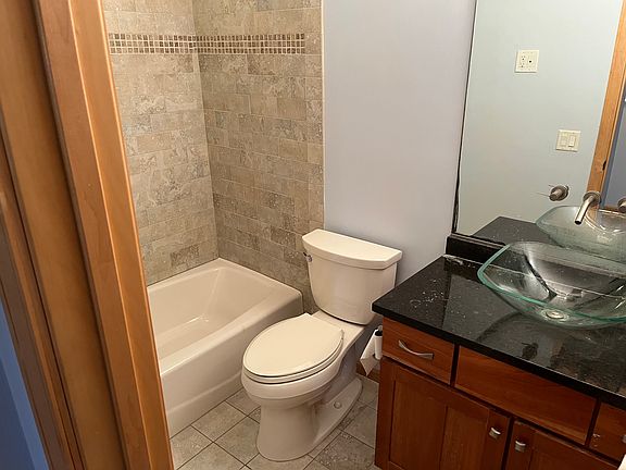 Main bathroom with rock tile floor and shower surround. Designer sink