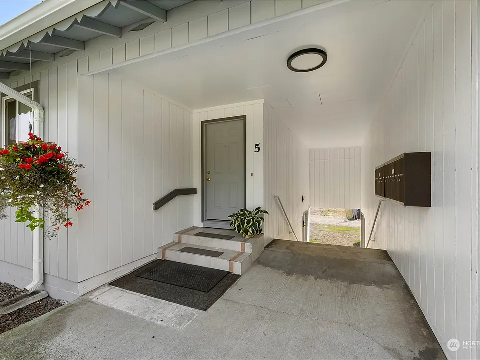 Covered entry for unit 5 and the breezeway leads to the mailboxes and laundry facility>