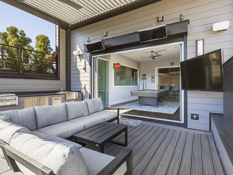 Spacious rooftop patio with a cozy fireplace, BBQ grill, outdoor TV, retractable Nano wall, adjustable louvered roof, LED lighting, wall heaters and plenty of lounge and dining seating_perfect for relaxing evening under the Nashville sky.
