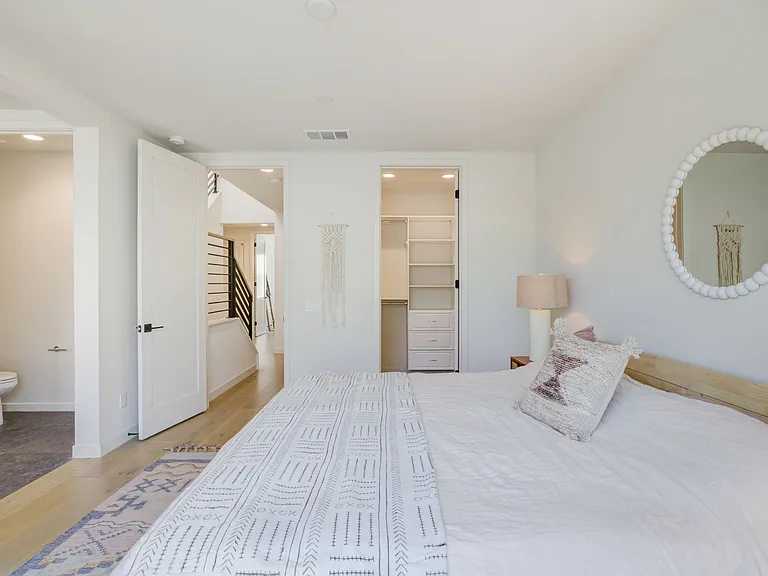 Primary suite featuring a spacious walk-in closet and a private ensuite bathroom.