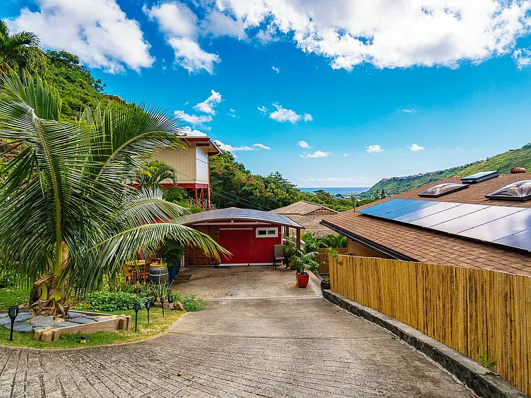 secluded cul de sac; bamboo fence along driveway leading to carport; driveway sloped and curved