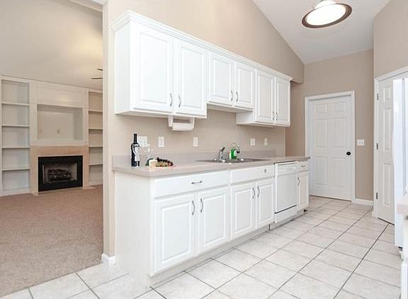 Clean white cabinets with crown molding and tiled floor