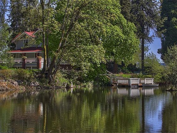 Beautiful trees & flowering pots surround this homestead. Pond out front with boat dock for small watercraft. Complete with Swan named Curtis!