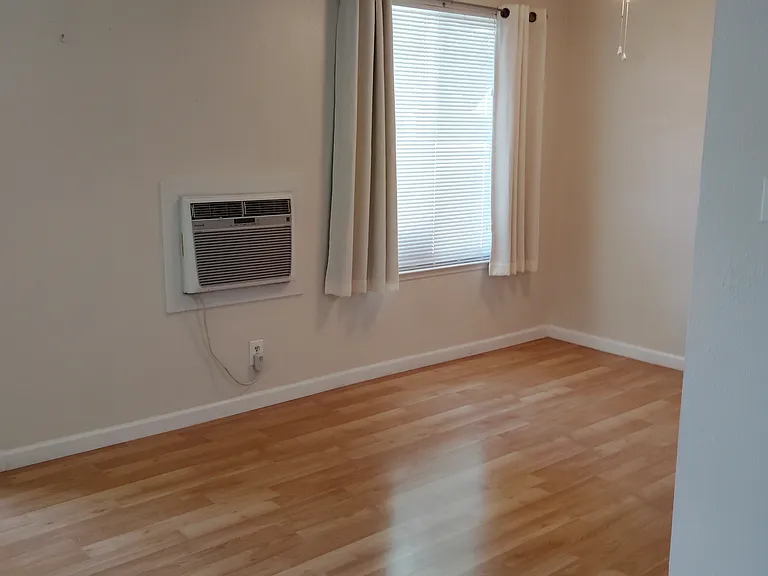 Dining area includes window coversings and Wall Unit Air Conditioner
