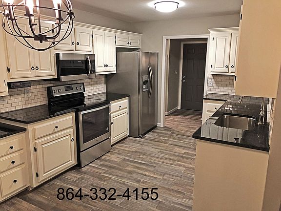 Updated kitchen with granite counters, stainless steel appliances, and title backsplash