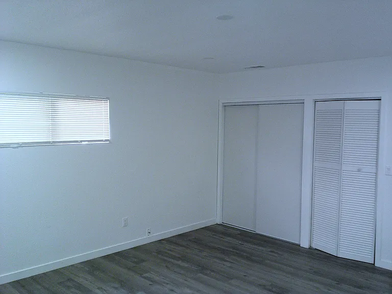 Bedroom 3, facing dual closet spaces.