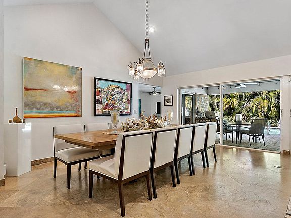 Dining room accommodates a large dining table and overlooks covered patio and pool.