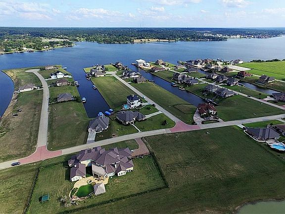 This amazing Mediterranean Villa sits on .65 of an acre overlooking Lake Conroe. It includes 2 waterfront lots with a double drive way on St Ann Crt and it fronts Decatur in the French Quarter, a gated community!