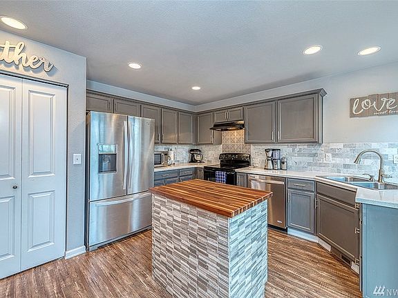 Bright and cheery kitchen, new marble backsplash, breakfast bar and acrylic counters. Pantry and a slider to the Trex deck.