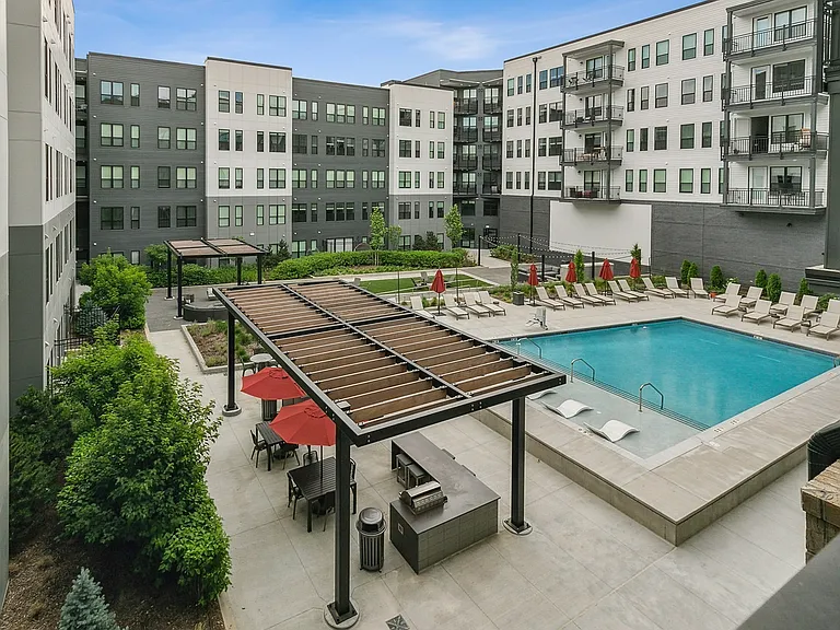 Enjoy the perfect mix of sun and shade with inviting poolside seating and a charming pergola retreat.