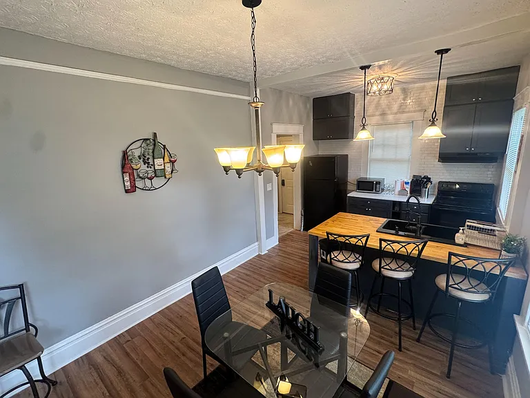 Eat-in kitchen with island seating, ample cabinetry, and subway-tile backsplash, plus adjacent dining space for gatherings.