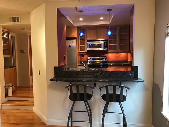 Kitchen view from dining with high chair seating at countert