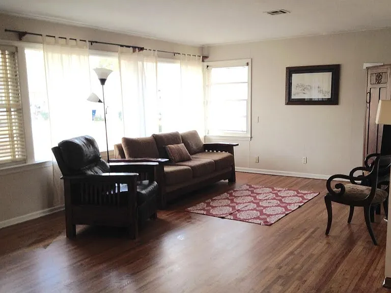 Large living room with picture windows and 3 double hung windows.