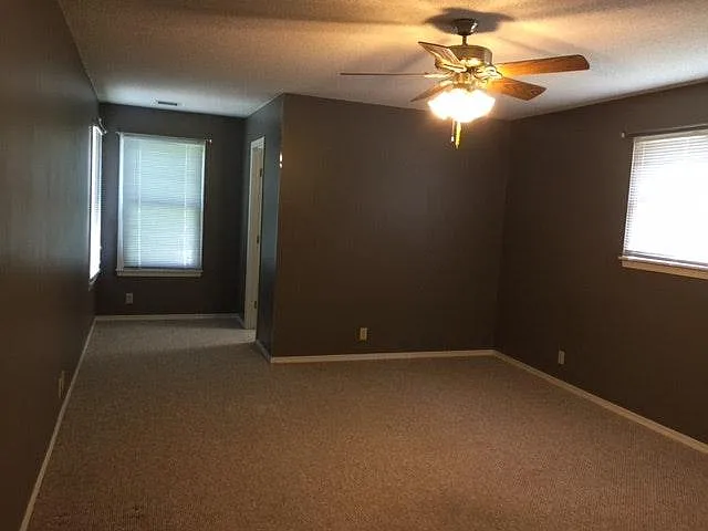 Master bedroom with carpet and walk in closet