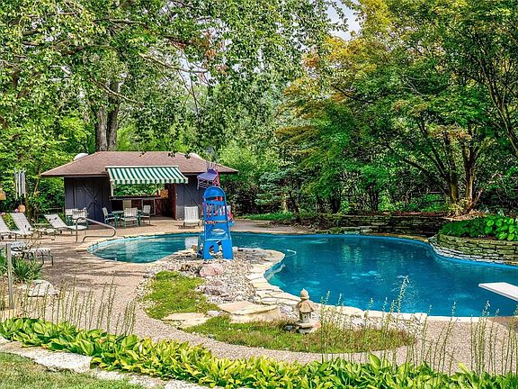 Private oasis in the backyard, featuring a free form pool and pool house with his/hers half baths and serving bar for entertaining!