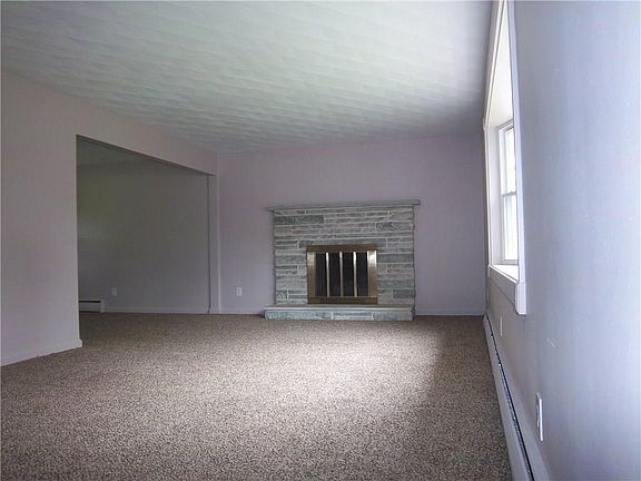 LIVING ROOM WITH WOOD BURNING FIREPLACE WITH STONE FRONT, BRAND NEW CARPETING AND FRESHLY PAINTED ROOM,BRAND NEW  BOW WINDOW. BEAUTIFUL CUSTOM TEXTURED CEILINGS