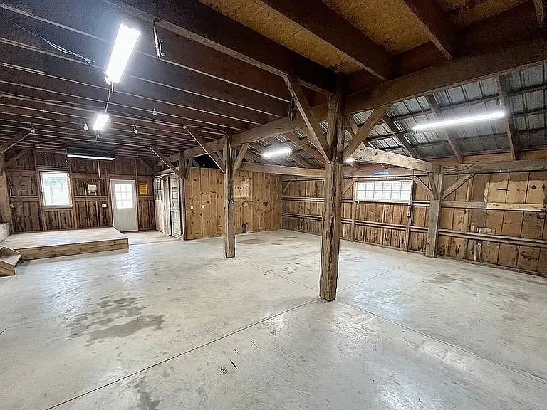 Expansive lower level of the barn featuring rustic timber framing.