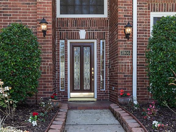 A covered entry leads to the wood and leaded-glass front door.