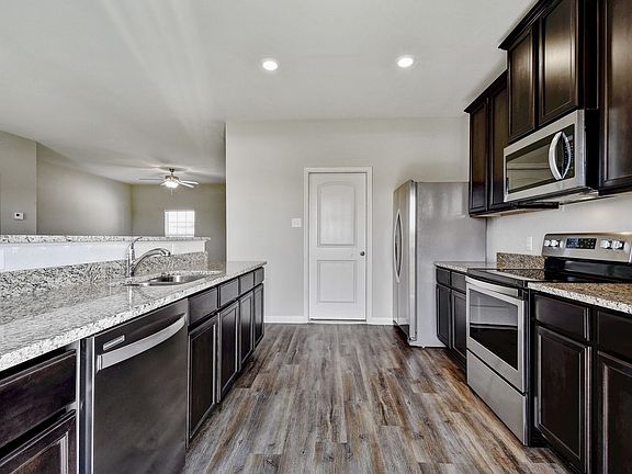 The kitchen is open to the living area and has gorgeous, wood-like flooring and granite countertops.