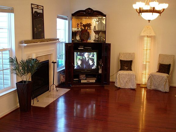This Cozy Living Room has Cherry Hardwoods that Accent the Charming Gas Log Fi
