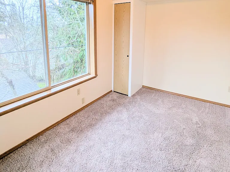 209 Smaller 2nd bedroom/office with vaulted ceiling, small closet, and storage above.