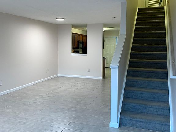 Living room view from front door towards kitchen and stairs.