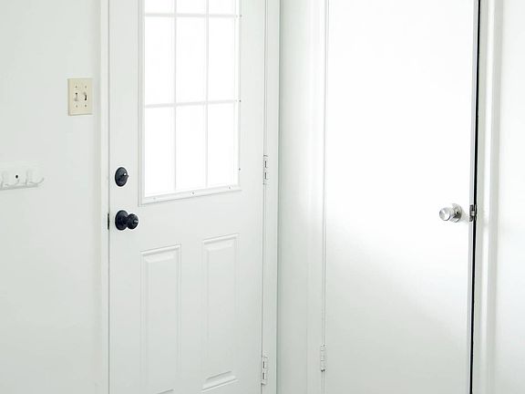 Living room view of front door, closet.