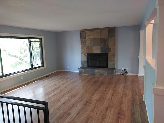 View of the living room from the entry stairs. There is fireplace is in good working condition.