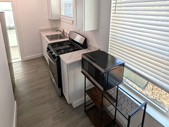 Kitchen with microwave and stand to hang pots included.