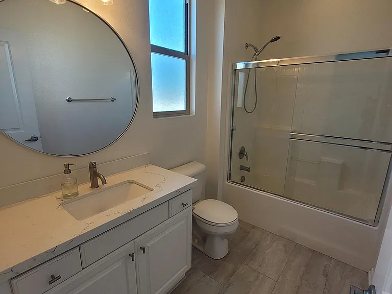 2nd Primary En-suite restroom featuring the same bright white and gray quartz countertop.