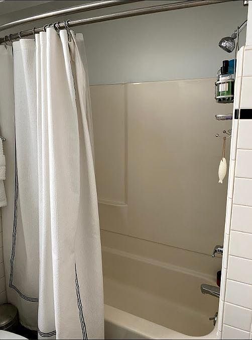 Tub/shower with new shower head and double rod hotel shower curtain rod.
