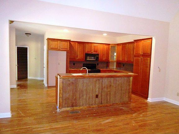 View of the large open kitchen from the great room. WOod floors and fresh paint in the living spaces