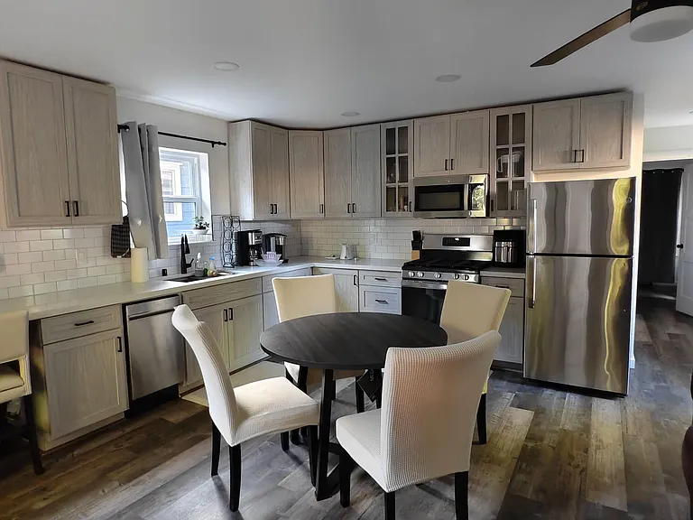 Spacious kitchen with ample cabinetry, subway-tile backsplash, stainless steel appliances, and an eat-in dining area.