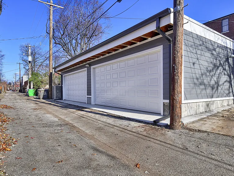 Garage features 8-foot-high doors, durable fiber-cement siding, and a reflective white roof designed with efficiency in mind.